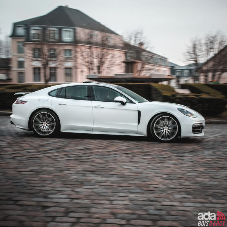 Porsche Panamera 4S blanche garée sur des pavés, à louer depuis Paris à l'agence 321ada de Bois-d'Arcy